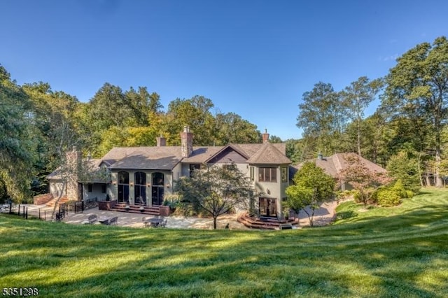 back of house with a yard and a patio
