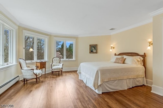 bedroom with a baseboard heating unit, wood finished floors, ornamental molding, and baseboards