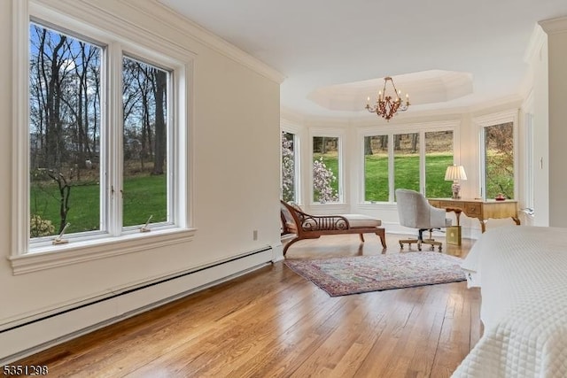 sunroom / solarium featuring a baseboard radiator, plenty of natural light, and a chandelier