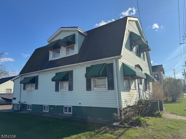 view of side of property featuring a yard and central AC unit
