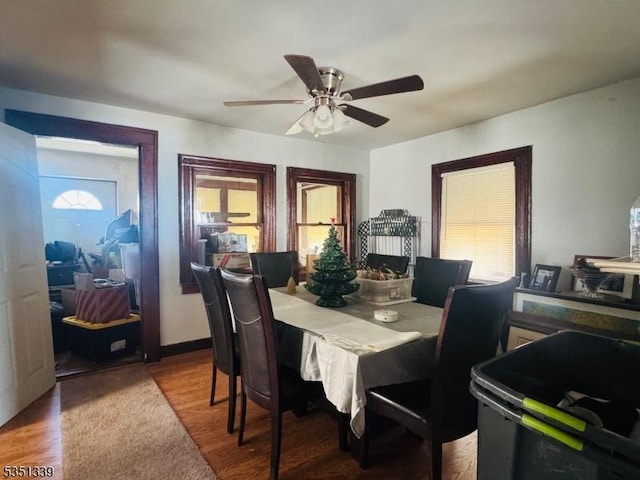 dining space with a ceiling fan and wood finished floors