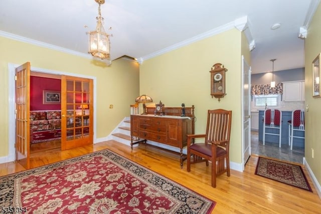 sitting room featuring baseboards, wood finished floors, french doors, and crown molding