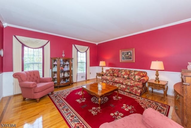 living area featuring wood finished floors and crown molding