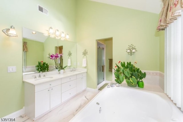 bathroom featuring double vanity, visible vents, a garden tub, and a sink