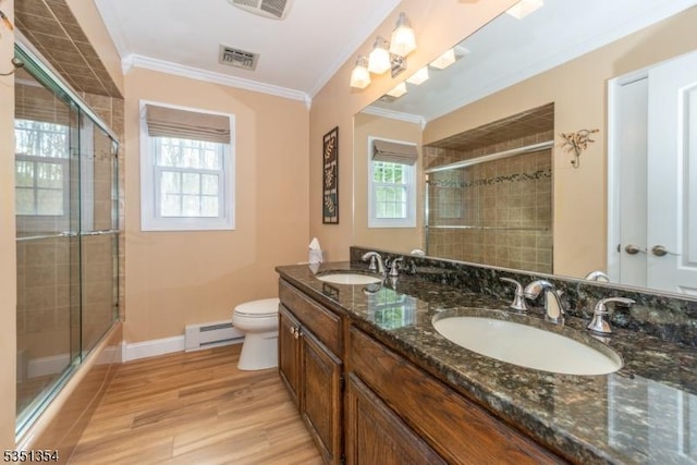 bathroom featuring baseboard heating, wood finished floors, crown molding, and a sink