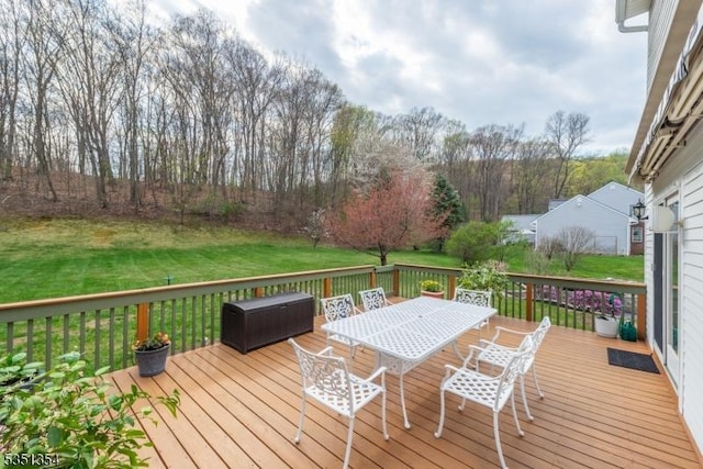 deck with a lawn and outdoor dining area