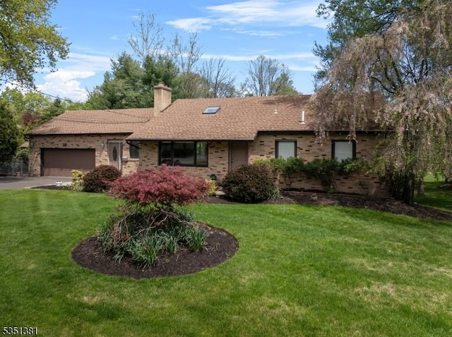 ranch-style home with brick siding, a garage, a chimney, and a front lawn