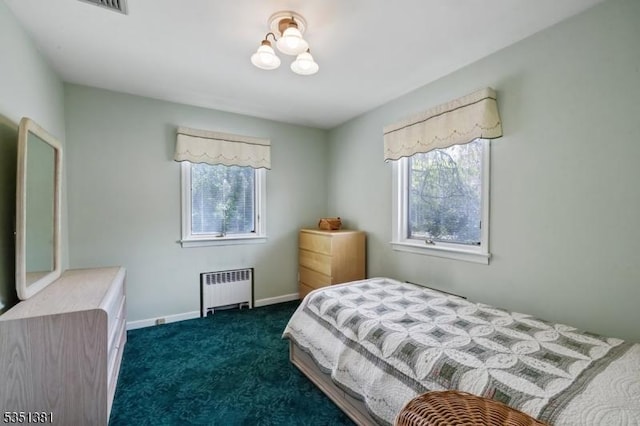 bedroom with baseboards, dark carpet, and radiator
