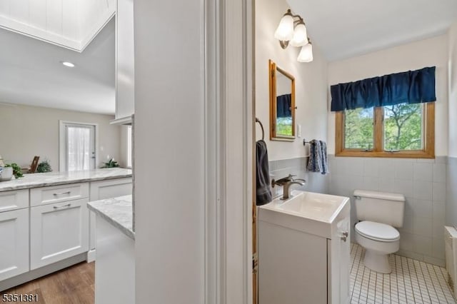 full bathroom featuring plenty of natural light, vanity, toilet, and tile walls