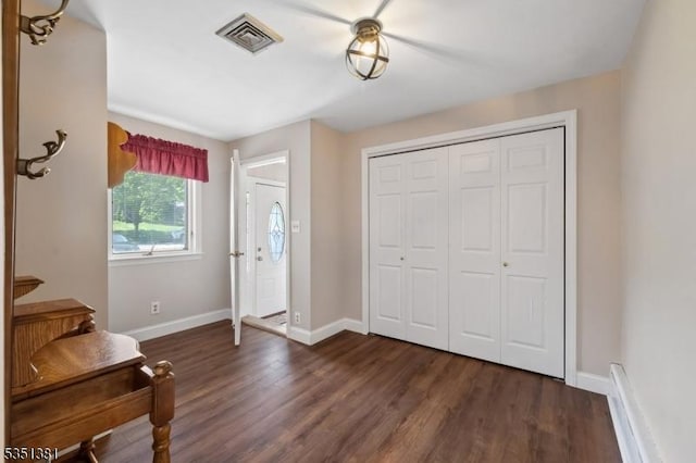 entryway with dark wood-style flooring, baseboards, and visible vents