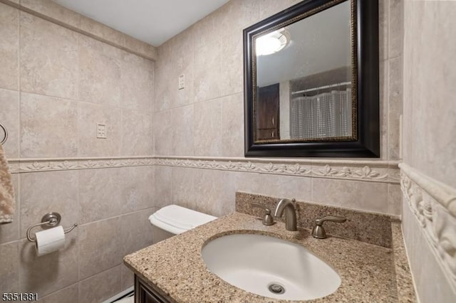 full bath featuring tile walls and vanity