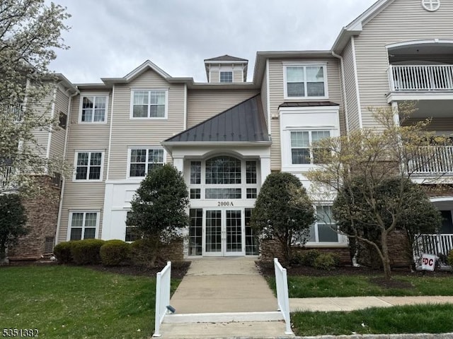 view of front of house featuring a standing seam roof, metal roof, and french doors