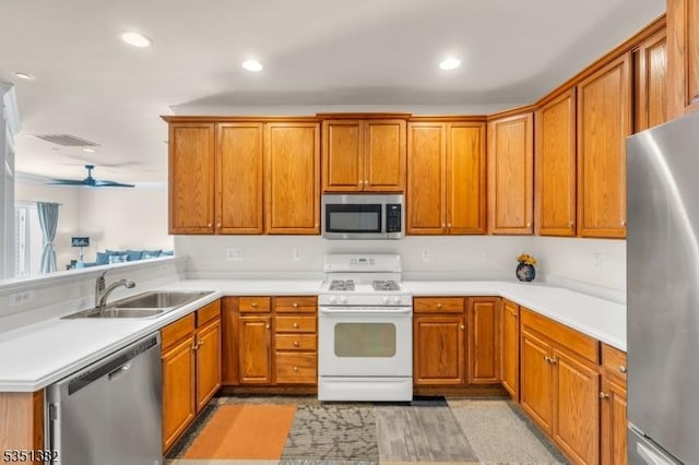 kitchen featuring brown cabinetry, visible vents, appliances with stainless steel finishes, and a sink