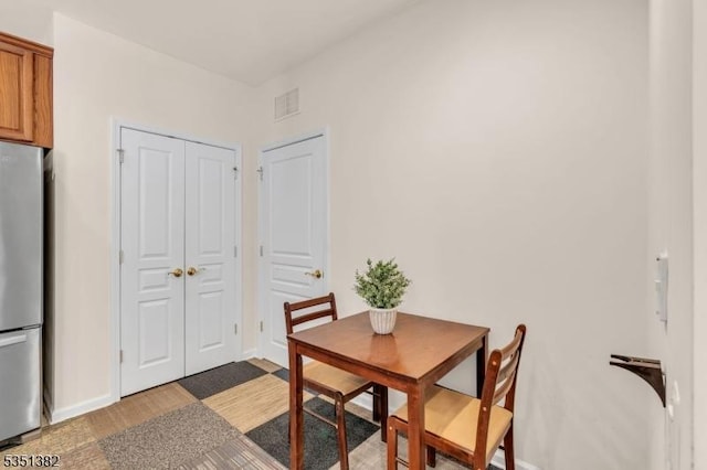 dining room with baseboards, wood finished floors, and visible vents