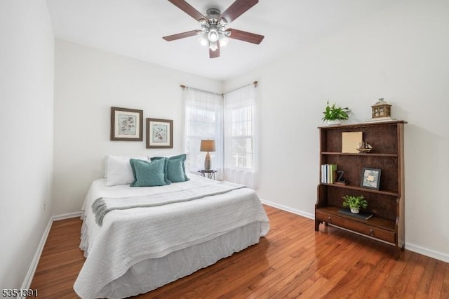 bedroom featuring baseboards, ceiling fan, and wood finished floors