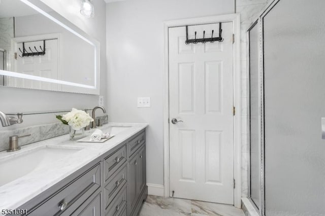 bathroom featuring double vanity, a sink, marble finish floor, and a stall shower
