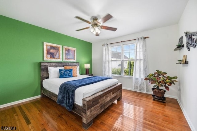 bedroom featuring baseboards, ceiling fan, and wood finished floors