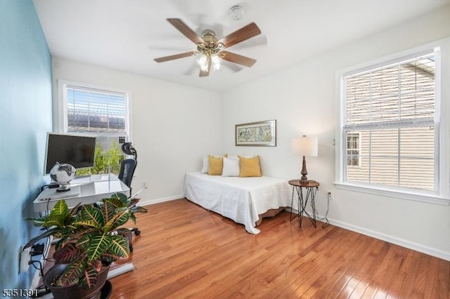 bedroom featuring baseboards, ceiling fan, and light wood-style flooring