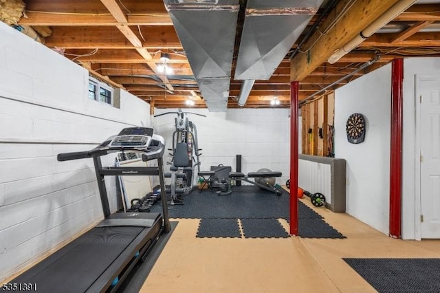 exercise room featuring concrete block wall