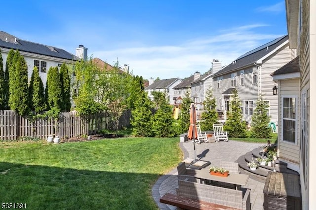 view of yard with a patio, fence, and a residential view