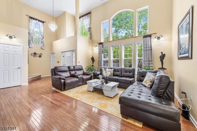 living area featuring plenty of natural light, a high ceiling, and hardwood / wood-style flooring