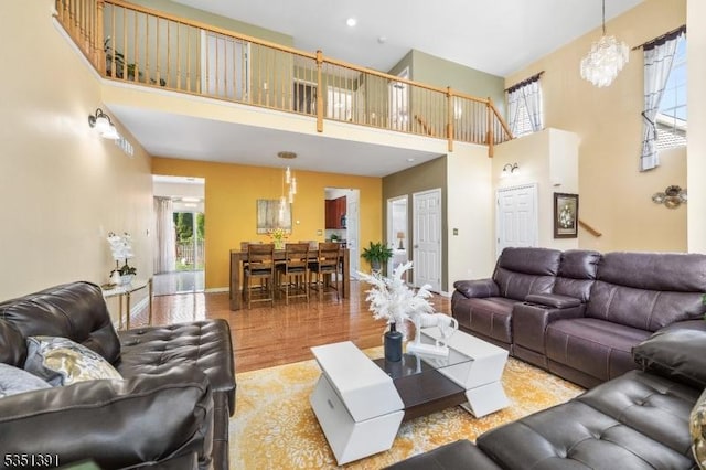 living area with baseboards, a high ceiling, and wood finished floors