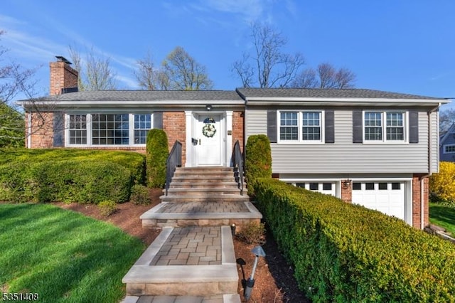 view of front of house featuring brick siding, an attached garage, and a chimney