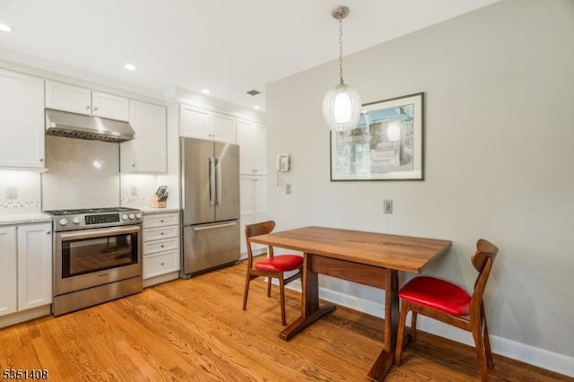 kitchen featuring white cabinetry, light wood finished floors, under cabinet range hood, and stainless steel appliances