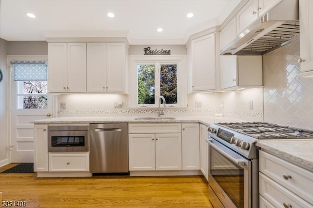 kitchen with appliances with stainless steel finishes, a sink, backsplash, recessed lighting, and under cabinet range hood