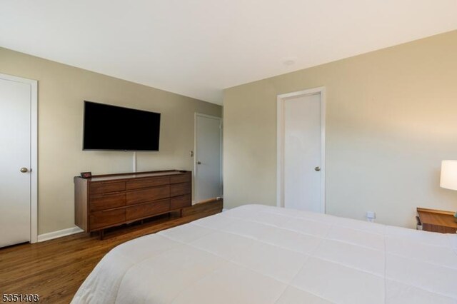 bedroom with baseboards and wood finished floors