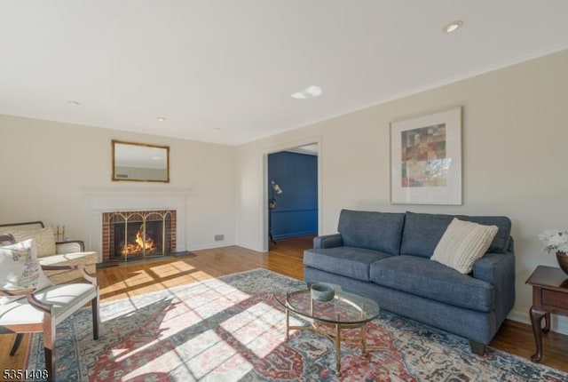 living room with baseboards, a fireplace, and wood finished floors