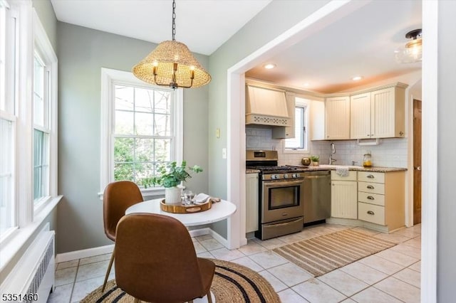kitchen featuring decorative backsplash, decorative light fixtures, an inviting chandelier, stainless steel appliances, and wall chimney exhaust hood