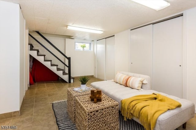 sitting room with light tile patterned flooring and stairway