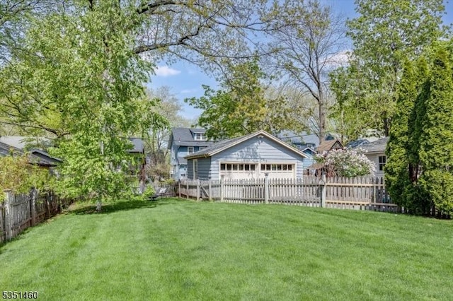 view of yard featuring a detached garage and fence private yard