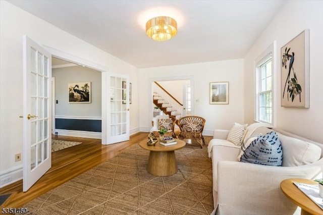 living area with baseboards, french doors, and wood finished floors