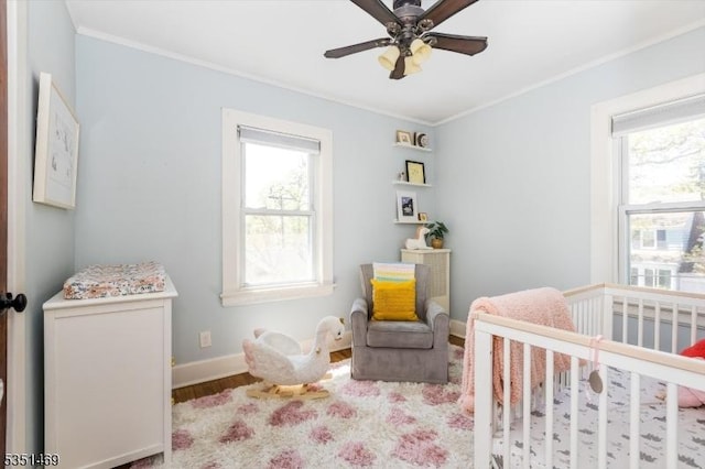 bedroom featuring ornamental molding, a crib, and multiple windows