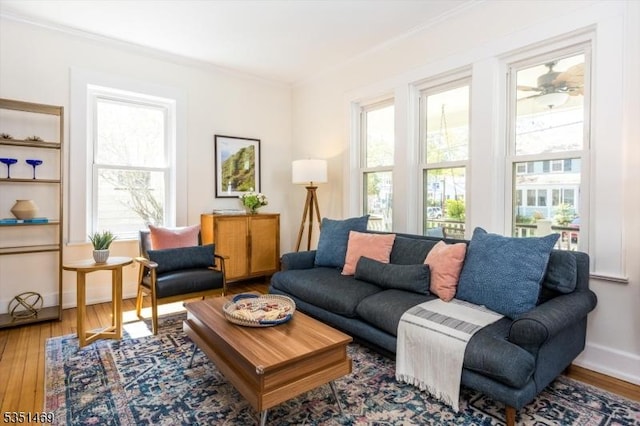 living room with baseboards, ornamental molding, and wood finished floors
