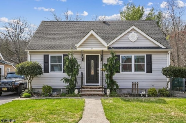 bungalow-style house with a shingled roof, entry steps, and a front yard
