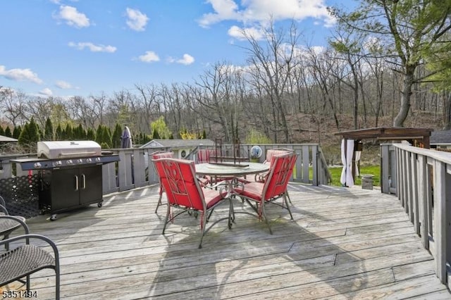 wooden terrace with grilling area and outdoor dining space