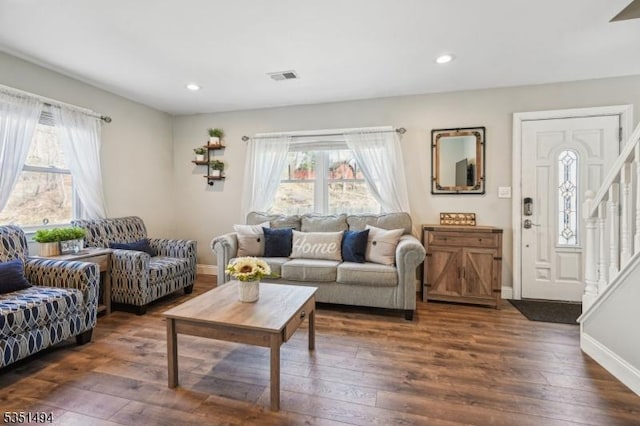 living area featuring plenty of natural light, visible vents, and dark wood-style flooring