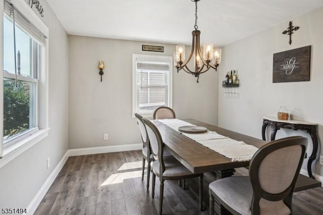 dining space with baseboards, dark wood-style floors, and an inviting chandelier