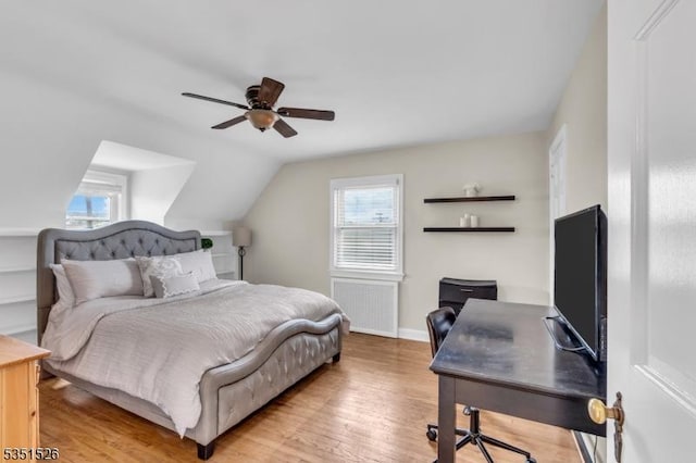 bedroom featuring lofted ceiling, light wood finished floors, baseboards, and multiple windows