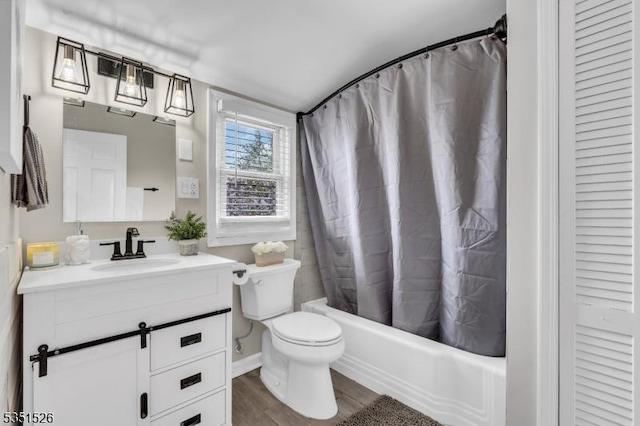 full bathroom with wood finished floors, toilet, vanity, and shower / tub combo with curtain