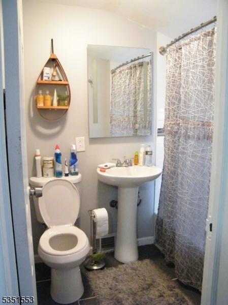 full bath featuring toilet and curtained shower