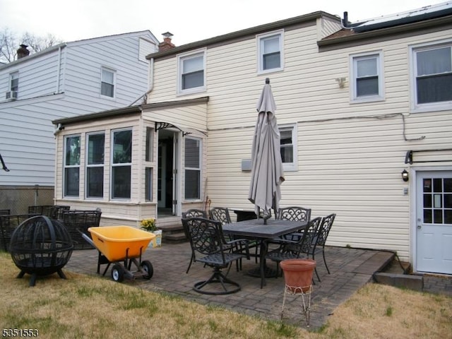 back of house featuring an outdoor fire pit and a patio area
