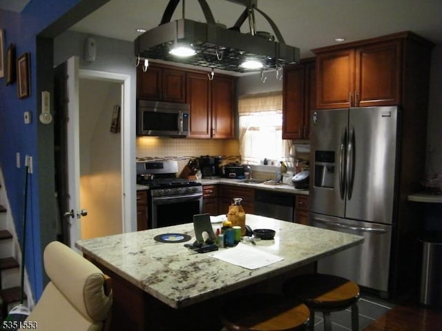 kitchen featuring a kitchen bar, light stone countertops, and stainless steel appliances