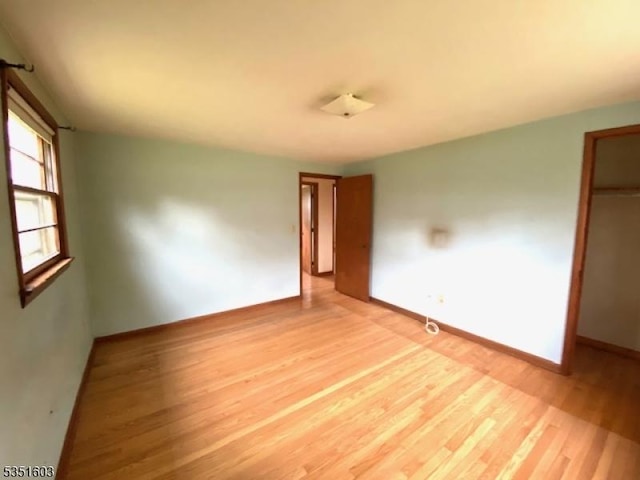 unfurnished bedroom with baseboards and wood finished floors