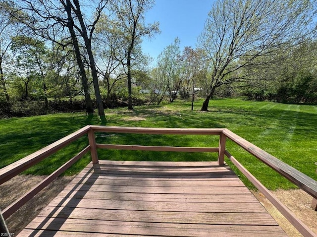 wooden deck featuring a lawn