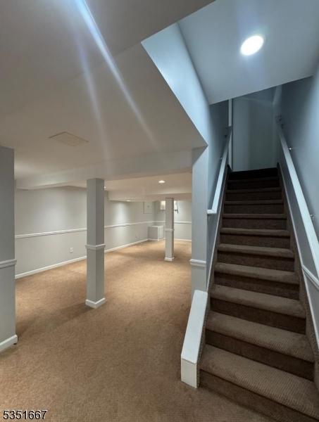 stairway featuring carpet floors and baseboards