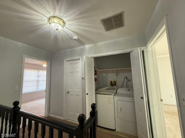 laundry room featuring visible vents, laundry area, washing machine and dryer, baseboards, and carpet flooring